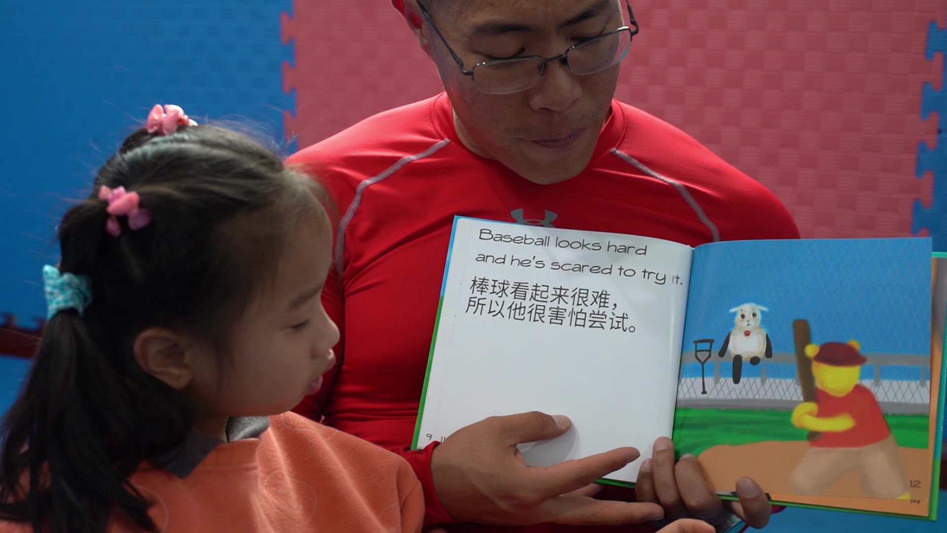 David Pat reading a bilingual children's book to a girl in Shanghai