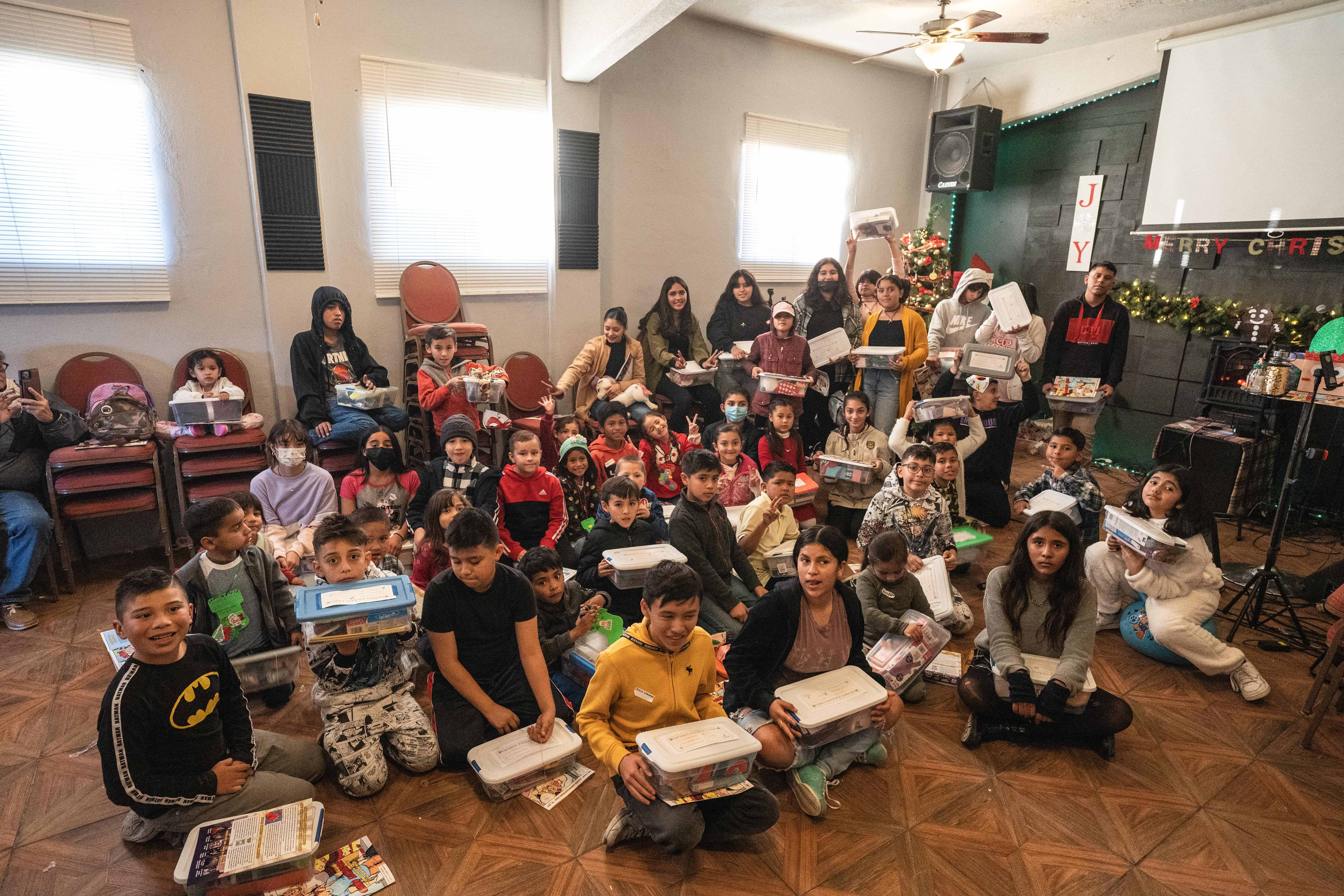 Children receiving gift boxes at Christmas Outreach event